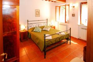 sypialnia z łóżkiem z zieloną narzutą w obiekcie Monte Malbe Charming Villa with Garden and Parking w mieście Perugia