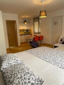 a bedroom with a white bed and a kitchen at Apartment Lara in Rab