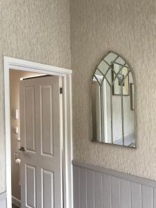 a bathroom with a door and a mirror on the wall at The Annex Apartment is on Cheddar Bridge Apartments in Cheddar