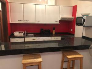 a kitchen with white cabinets and a black counter top at Playa Park in Los Pocillos