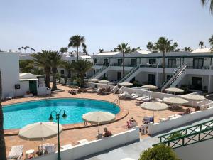 Una piscina con sombrillas y un resort. en Playa Park, en Los Pocillos