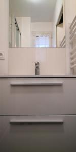La salle de bains est pourvue d'un lavabo et d'un miroir. dans l'établissement STUDIO Cabourg Résidence LES GEMEAUX, à Cabourg