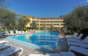 a hotel with a swimming pool and lounge chairs at Hotel Baia Verde in Malcesine