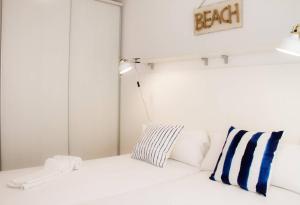 サロウにあるDomatsea Salou Mediterraniの白いベッド(青と白の枕付)