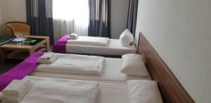 
A bed or beds in a room at Hotelpension Margrit
