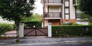 une maison avec une porte en bois devant elle dans l'établissement STUDIO Cabourg Résidence LES GEMEAUX, à Cabourg