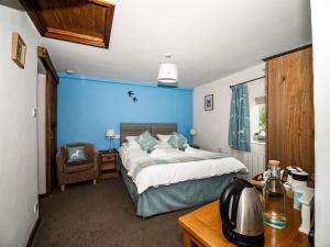 1 dormitorio con cama y pared azul en Stag's Head, en Banbury