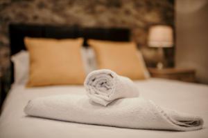 a white towel sitting on top of a bed at The Wroxeter Hotel in Wroxeter