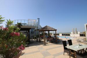 a patio with a table and umbrella and a pool at Eraclea Palace Appartements in Eraclea Mare