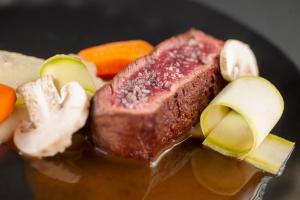 a piece of meat and vegetables on a plate at Vivid Blue Serenity Resort in Sveti Stefan