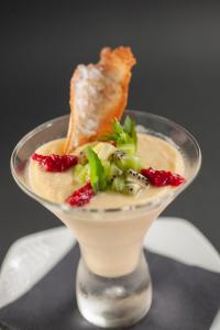 a dessert in a glass dish with fruit and greens at Vivid Blue Serenity Resort in Sveti Stefan