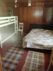 een slaapkamer met een bed, een stoel en een tapijt bij Chata u Kuba in Kraľovany