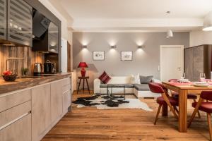 a kitchen and living room with a table and a couch at Apartments Greisslerei in Aich