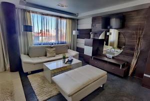 a living room with a couch and a mirror at Hotel Acktion in Shumen