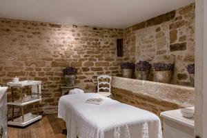 a spa room with a white table and chairs and brick walls at Hotel Crillon le Brave in Crillon-le-Brave