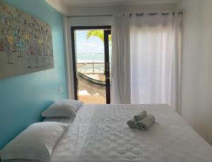 a bedroom with a bed with a view of the beach at Casa Praia da Pipa in Pipa