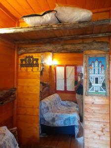 mężczyzna robiący zdjęcie sypialni w drewnianym domku w obiekcie Agriturismo Monte Cesima w mieście Sesto Campano