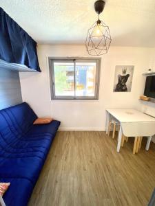 a living room with a blue couch and a table at Boost Your Immo Les Deux Alpes Kandahar 357 in Les Deux Alpes