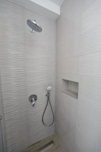 y baño con ducha con cabezal de ducha. en Apartmani Marina s pogledom, Sukošan, en Sukošan