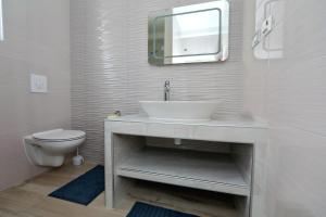 Baño blanco con lavabo y aseo en Apartmani Marina s pogledom, Sukošan, en Sukošan