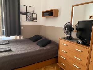 Dormitorio con cama y tocador con TV en Guest Rest Studio Apartments, en Budapest