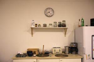 a kitchen with a clock on the wall and a counter at Onefam Notting Hill by Hostel One in London