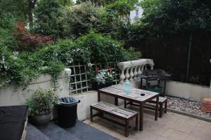a patio with a table and a grill in a backyard at Onefam Notting Hill in London