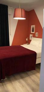 sypialnia z łóżkiem i czerwoną ścianą w obiekcie Alojamiento Weier w mieście Valladolid