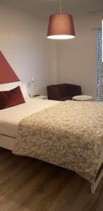 sypialnia z łóżkiem, krzesłem i lampką w obiekcie Alojamiento Weier w mieście Valladolid