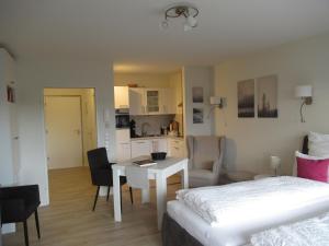 ein Schlafzimmer mit einem Bett und einem Tisch sowie eine Küche in der Unterkunft Loreley Lounge in Patersberg