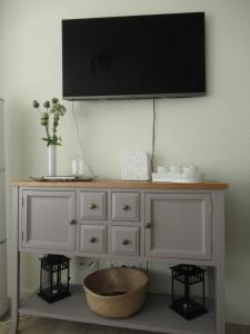 een witte dressoir met een televisie aan de muur bij Loreley Lounge in Patersberg