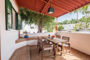 a patio with a wooden table and chairs on a balcony at Casa Verode - Villa Perenquén in Guía de Isora