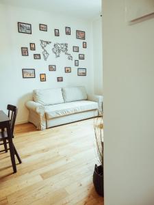 un soggiorno con divano e immagini appese al muro di BRE Apartments - Gambero Flat a Vicenza