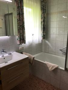 łazienka z wanną, umywalką i lustrem w obiekcie Landhaus Montana w mieście Gerlos +5 zdjęć