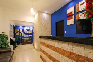 a lobby with a blue wall and a bar at Hostal Gayser in Valladolid