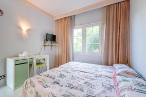a bedroom with a bed and a desk and a window at Villa Son Ferrer in Santa Ponsa +18 photos
