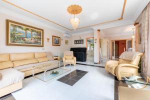 a living room with a couch and chairs at Villa Son Ferrer in Santa Ponsa