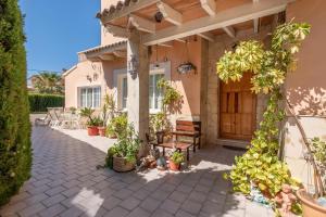 a porch of a house with a bench and plants at Villa Son Ferrer in Santa Ponsa