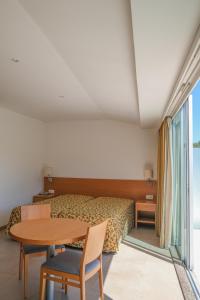 Schlafzimmer mit einem Bett und einem Tisch mit Stühlen in der Unterkunft Aparthotel Vouga in Termas de Sao Pedro do Sul