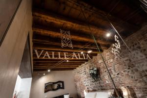 um quarto com uma parede de tijolos e um sinal que lê valor atarma em La Bella Verona Wine Suite em Verona