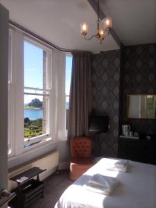 a bedroom with a bed and a large window at Glenleigh Bed and Breakfast in Marazion