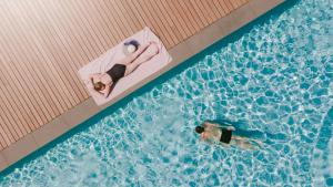 two people swimming in a swimming pool at Domaine la Pierre Blanche in Eygalières