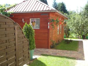 a red shed with a fence in front of it at Apartament wSPAniały. in Kowary