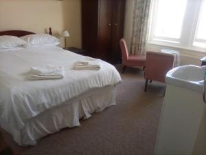 a hotel room with a bed with towels on it at Glenleigh Bed and Breakfast in Marazion