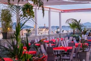 a restaurant with red tables and chairs on a roof at Hotel Terme Neronensis in Pozzuoli