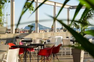 un ristorante con tavoli e sedie con vista sull'oceano di Hotel Terme Neronensis a Pozzuoli