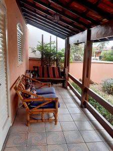 a porch with two chairs on a house at Franca Maya Hostel in Campinas