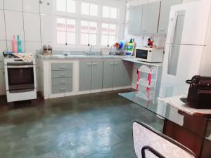 a white kitchen with a sink and a stove at Franca Maya Hostel in Campinas