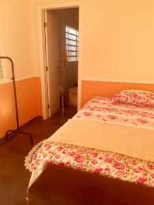 a bedroom with a bed with a floral bedspread at Franca Maya Hostel in Campinas