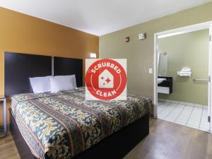 una habitación de hotel con una cama con un cartel. en OYO Hotel Lake Charles Hwy 10, en Lake Charles